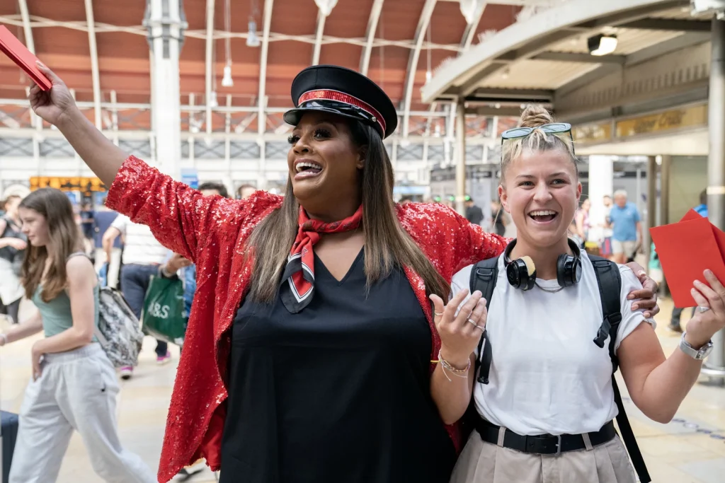 Two people smiling together during the Virgin Trains Ticketing station campaign